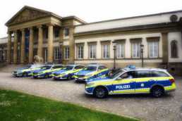 Lichtbild von fünf blauen Polizeistreifenwägen mit gelben Reflektionsstreifen